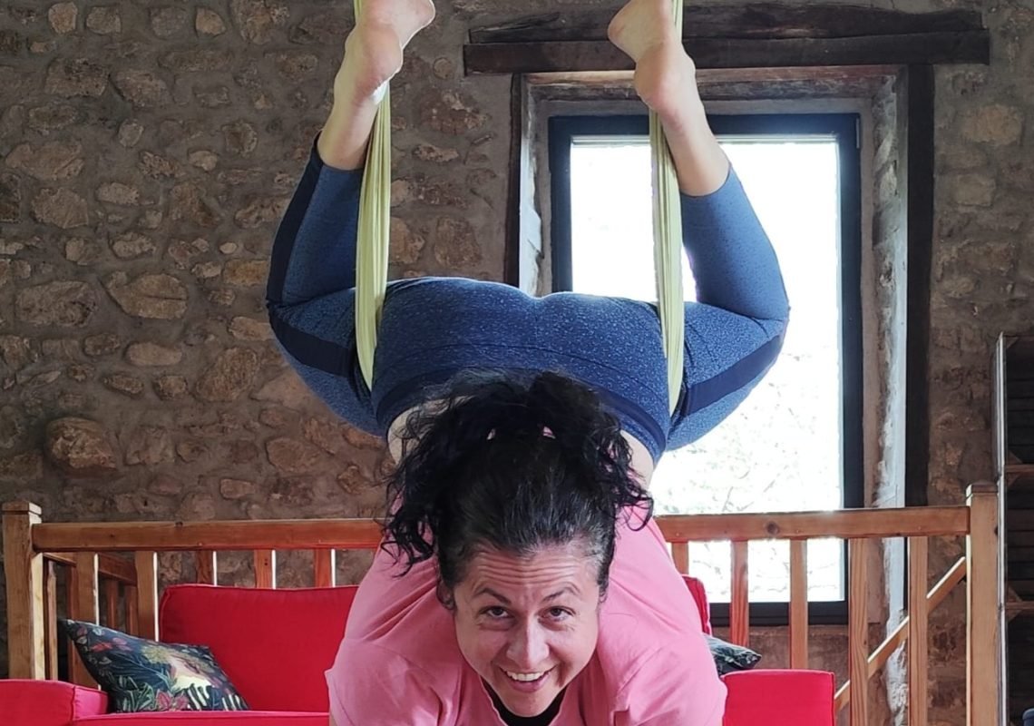 Audrey, professeure de yoga aérien en Ardèche, en posture inversée dans un hamac de fly yoga